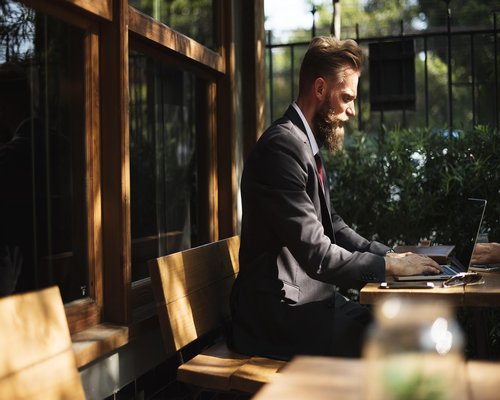 Person typing on a laptop at a cafe table
